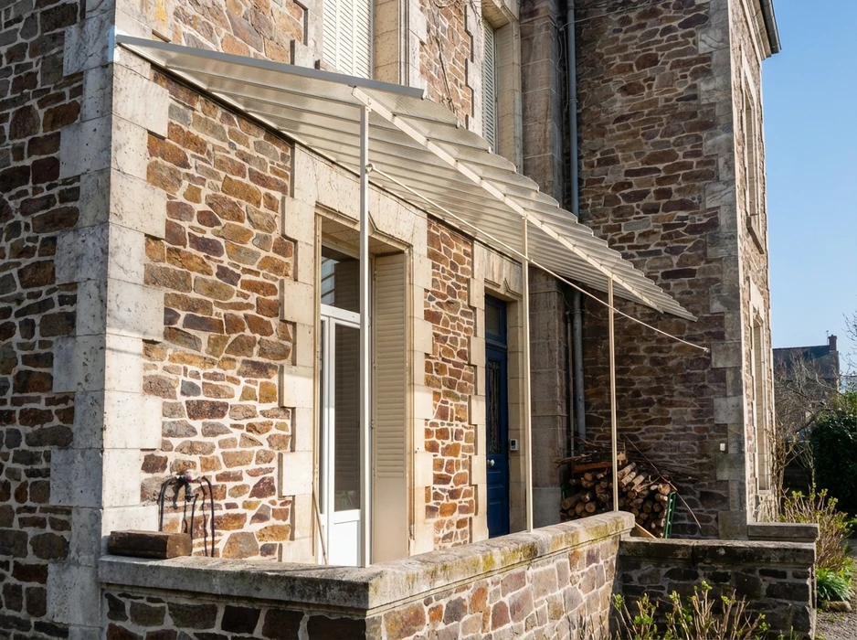 Façade extérieure d'un bâtiment en pierre de taille apparente, murs en moellons de granite brun-roux avec encadrements en pierre calcaire blanche