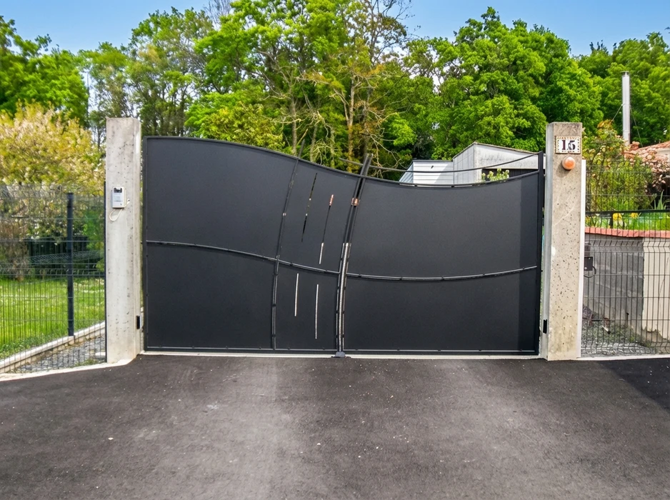 Portail battant double vantaux en acier laqué noir mat, design contemporain avec découpes géométriques ondulées et poignées inox