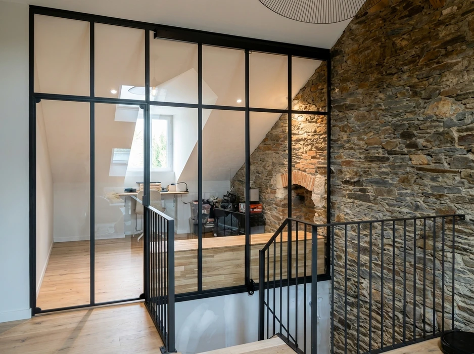 Verrière atelier en acier noir séparant un couloir d'un bureau mansardé sous combles