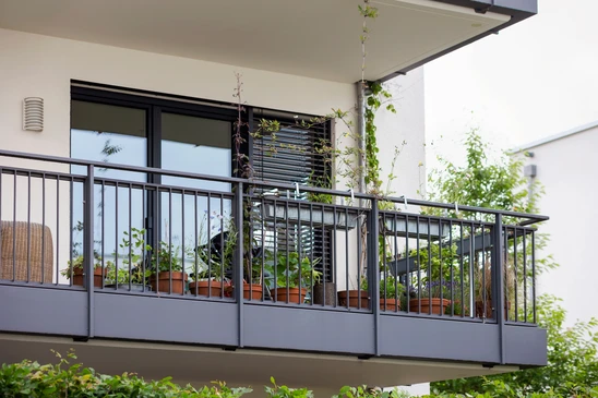 Façade d'immeuble résidentiel moderne avec balcons à garde-corps métalliques noirs