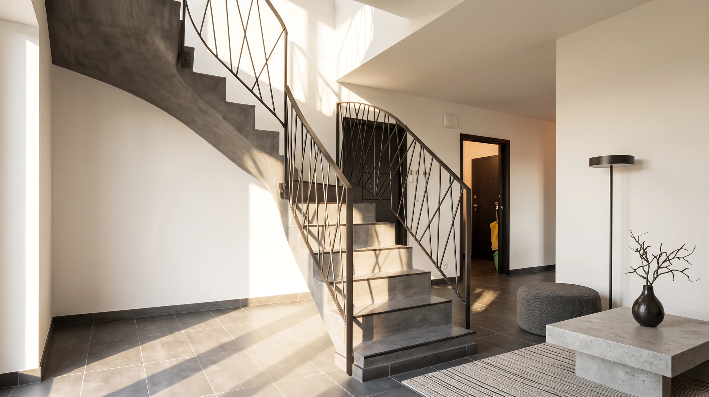 Escalier courbe intérieur moderne dans un hall d'entrée aux murs blancs