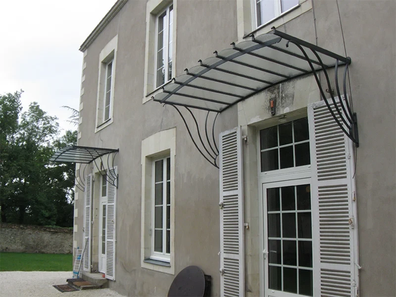 Palier d'étage avec garde-corps en acier noir mat et panneaux en verre trempé, vue depuis le haut d'un escalier